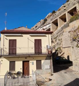 ein Gebäude mit Balkon und ein Auto, das direkt daneben parkt in der Unterkunft La Petite Maison in Pietrapertosa