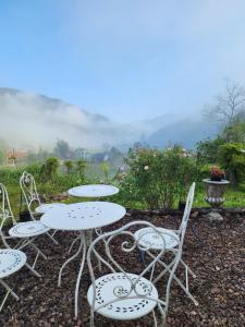 a group of tables and chairs with mountains in the background at Casa Ya Thip in Ban Huai Ti