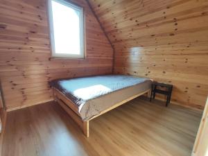 TobołowoにあるDomek Tobołowoの窓付きのログキャビンのベッド1台分です。