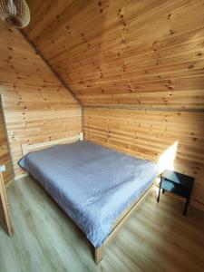 TobołowoにあるDomek Tobołowoの木造キャビン内のベッド1台が備わるベッドルーム1室を利用します。