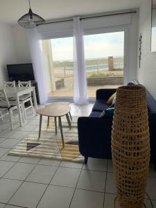 a living room with a blue couch and a table at Maeva 7 in Guidel