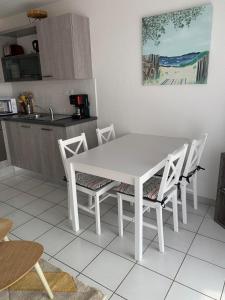 a white dining room table and chairs in a kitchen at Maeva 7 in Guidel