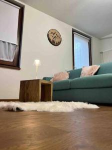 a living room with a blue couch and a table at Maison Poluc - Petit Bijou in Champoluc
