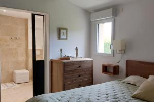 a bedroom with a bed and a sink and a mirror at La Clemensane in Lacoste