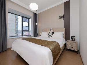 a bedroom with a large bed with a large window at Annie Apartment 2105 in Kunming