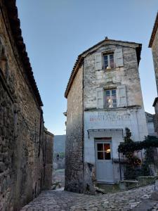 un antiguo edificio de piedra con una ventana en una calle en La Clemensane, en Lacoste