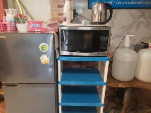 皮皮岛幸运宿舍旅舍的冰箱旁的架子上有一个微波炉