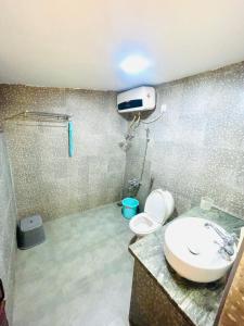 a bathroom with a toilet and a sink and a shower at Balacalava Guest House in Coonoor