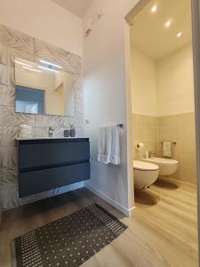 a bathroom with a sink and a toilet and a mirror at La Casa Vacanze di Grace in Follonica