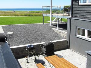 eine Terrasse mit einer Bank, einem Grill und einem Tisch in der Unterkunft Luxury Retreat in Ebeltoft - By Traum Ferienwohnungen in Ebeltoft