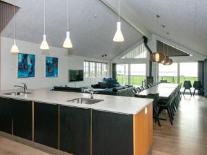 a kitchen with two sinks and a living room at 5 star holiday home in Ebeltoft in Ebeltoft +43 photos