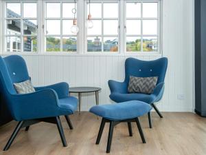 two blue chairs and a table in a room with windows at 5 star holiday home in Ebeltoft in Ebeltoft
