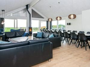 a room with black leather couches and chairs at 5 star holiday home in Ebeltoft in Ebeltoft