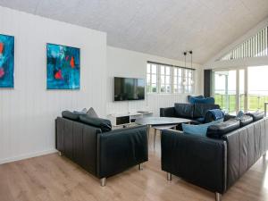 a living room with two leather couches and a table at 5 star holiday home in Ebeltoft in Ebeltoft