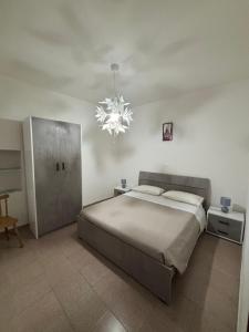 Un dormitorio con una cama grande y una lámpara de araña. en I Trecento, en Padula