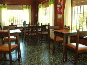 a dining room with tables and chairs and windows at LalomitaGesell in Villa Gesell