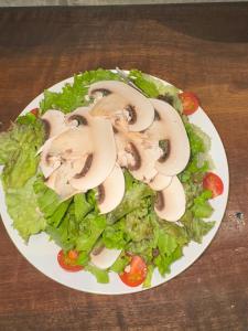 a plate of salad with mushrooms and lettuce on a table at HANABI棟 8人宿泊 サウナあり ペット不可 - Base棟 4人宿泊 サウナなし ペット可 - 貸切で最大12名宿泊OK in Katori