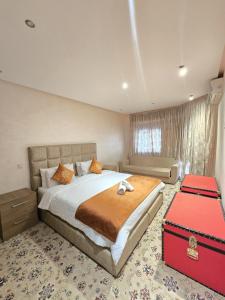 1 dormitorio con 1 cama grande y 1 maleta roja en Beach View Appartement, en Tánger
