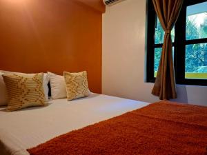 une chambre avec un lit avec des oreillers et une fenêtre dans l'établissement Agonda by Casa de Palmora, à Palolem