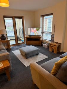 a living room with a couch and a flat screen tv at Quirky and spacious in Lawley Bank