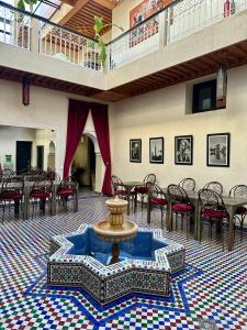 a large room with a fountain and tables and chairs at Villa Atika in El Bougaria