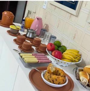 uma mesa com pratos de comida e frutas sobre ela em Hospedagem cama e café em Domingos Martins