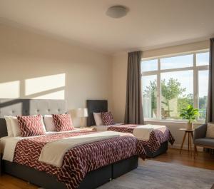 een slaapkamer met twee bedden en een groot raam bij Balkan Apart in Hasköy