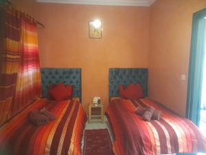 2 camas en una habitación con rojo y azul en riad zellige 95, en Marrakech 25 fotos más