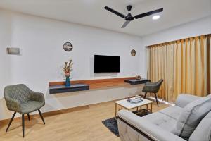 a living room with a couch and a tv at Charvi Suites in Pune