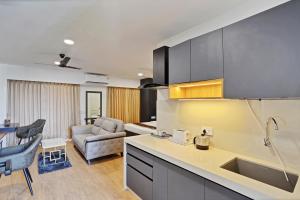 a kitchen with a sink and a living room at Charvi Suites in Pune +7 photos