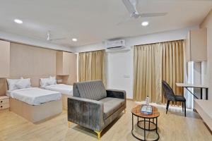 a hotel room with a bed and a chair at Charvi Suites in Pune