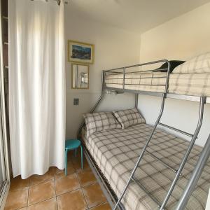 a small bedroom with a bunk bed and a bunk bedskirts at Nid des Angles - Cœur de station vue Lac & Montagne in Les Angles