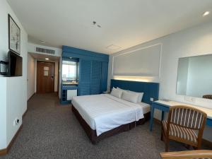 a bedroom with a bed with a blue wall at Hotel Continental Penang in George Town