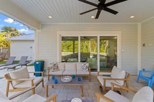 eine Veranda mit Stühlen, einem Sofa und einem Deckenventilator in der Unterkunft Golf Cart, Private Pool, Hot Tub, Two Beach Accesses in Santa Rosa Beach