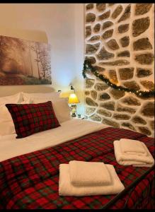a bedroom with a bed and a stone wall at Aggelos Gardenhouse of Volos in Volos