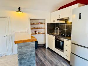 尚贝里Le Cocon du Centre - Home Cinéma & Calme的配有白色橱柜和台面的厨房