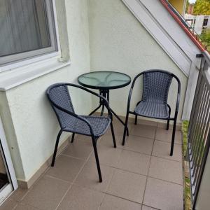 two chairs and a table on a balcony at Fiore Wellness Apartman in Zalakaros