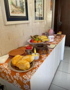 une table avec du pain et d'autres aliments dessus dans l'établissement Hospedagem cama e café, à Domingos Martins