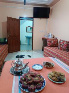 a room with a table with plates of food on it at Dar lkbira Azazoul in Taghazout