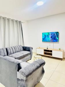 Una sala de estar con dos sofás y un televisor de pantalla plana. en Elusive Haven, en Nelspruit