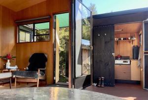 una casa con una gran puerta de cristal y una cocina en Cozy tiny house with view, en Thames