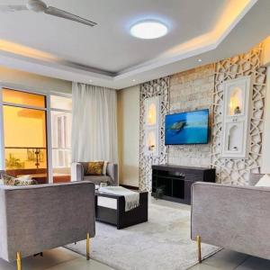 ein Wohnzimmer mit einem TV an einer Backsteinwand in der Unterkunft Home Sweet Home in Kisii