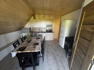 a large kitchen with a table and a refrigerator at Chata Pavlínka samota pri lese in Chvojnica