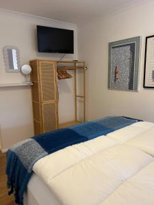 ein Schlafzimmer mit einem Bett und einem Fernseher an der Wand in der Unterkunft Stylish One Bedroom Apartment in Central Potton in Potton