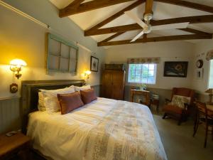 a bedroom with a large bed with a ceiling at Buttercup Cottage in Nottingham Road