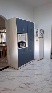 a kitchen with blue cabinets and a refrigerator at Casa Verão Cananéia in Cananéia