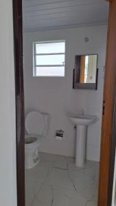 a bathroom with a toilet and a sink at Casa Verão Cananéia in Cananéia