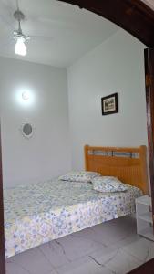 a bedroom with a bed in a white wall at Casa Verão Cananéia in Cananéia