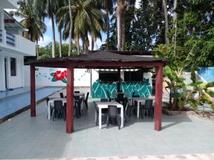 a gazebo with tables and chairs next to a pool at Apartamentos grigri in Río San Juan