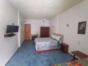 a bedroom with two beds and a flat screen tv at Apartamentos grigri in Río San Juan +32 photos